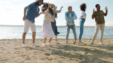 amigos bailando en la playa.
