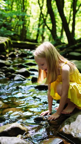 young girl exploring a forest stream