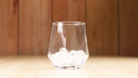 ice cubes falling into an empty glass
