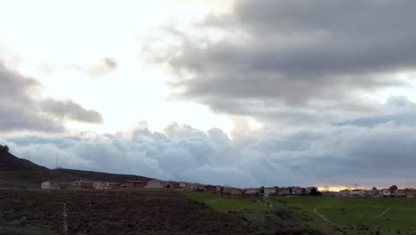 Aerial-dolly-shot-of-Raining-clouds-toward-residential-houses-in-Santa-Clarita-hill,-California