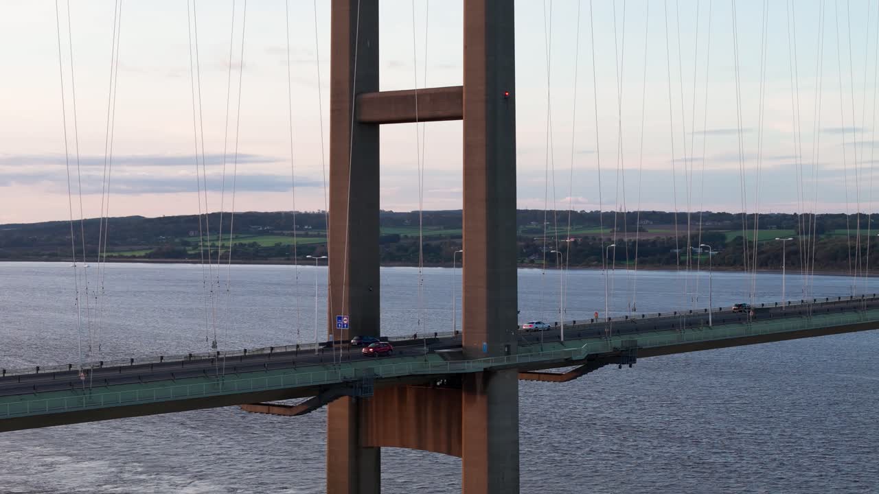 Twilight's embrace: An aerial drone unveils the Humber Bridge's splendor at sunset, with cars creating a tranquil tableau