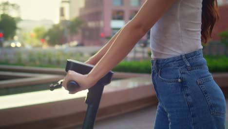 una chica linda usa una bicicleta eléctrica viendo la arquitectura. una mujer asiática conduce un scooter.