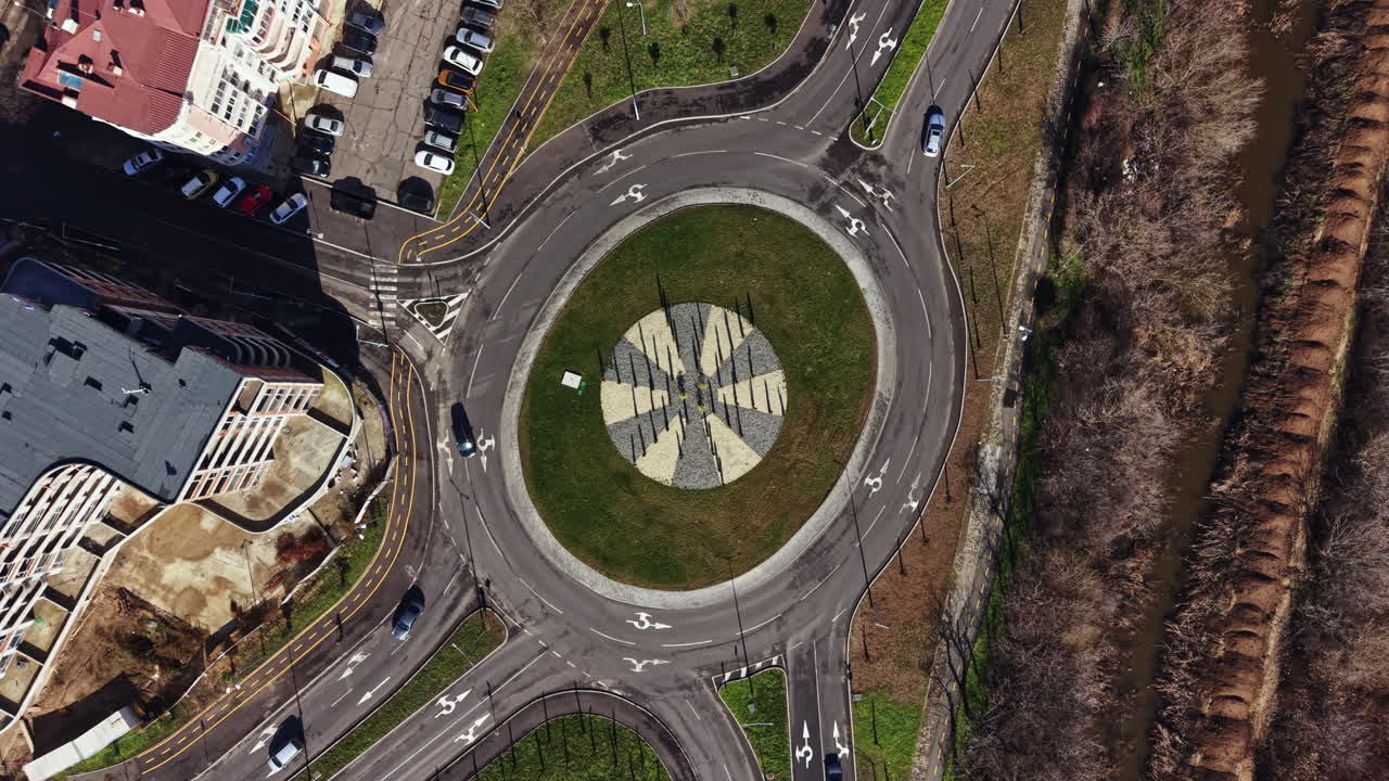 Vista di una rotonda in una città con auto sulla strada ed edifici ai lati durante il giorno