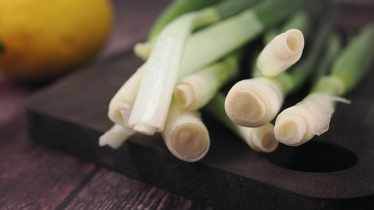 Fresh Green Onions on a Dark Wooden Cutting Board