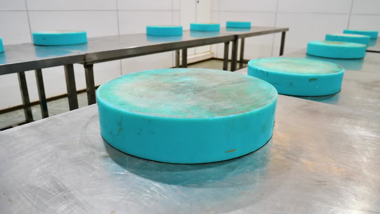 Thick, heavy-duty blue PE cutting chopping boards neatly arranged on stainless steel tables in a professional cooking school kitchen in China, emphasizing durability and hygiene.