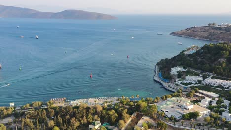 Luftdrohne-Schwenkt-Nach-Links-über-Das-ägäische-Meer-Voller-Boote-Auf-Dem-Blauen-Wasser-In-Der-Nähe-Von-Bodrum,-Wenn-Die-Sonne-Im-Sommer-über-Den-Hügeln-Der-Mugla-türkei-Untergeht