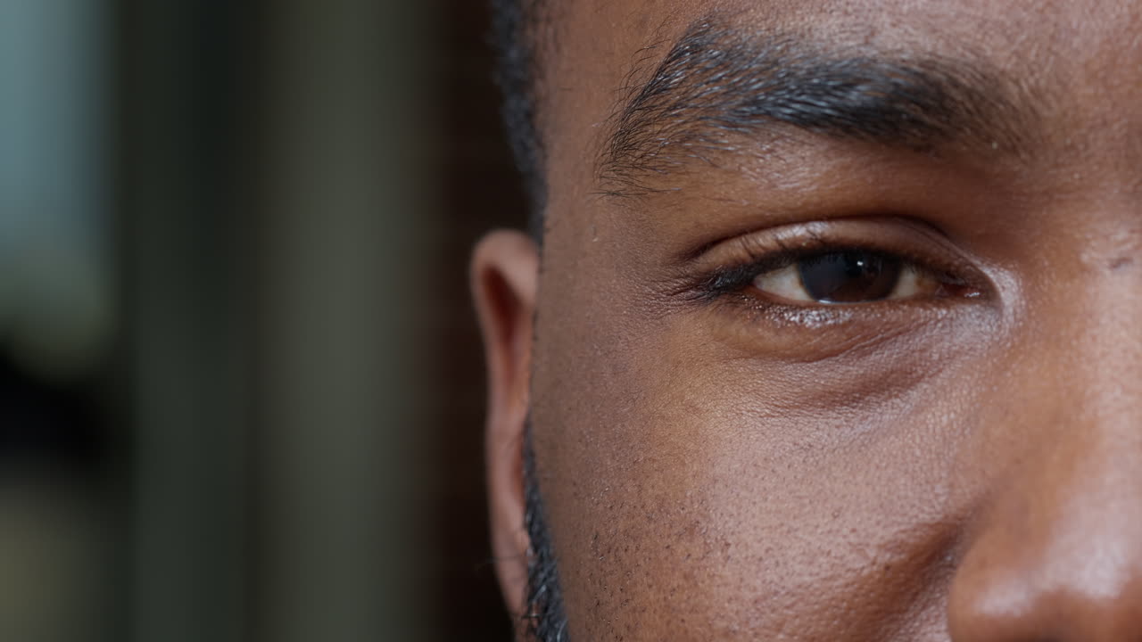 Macro shot of african american man showing one eye on camera