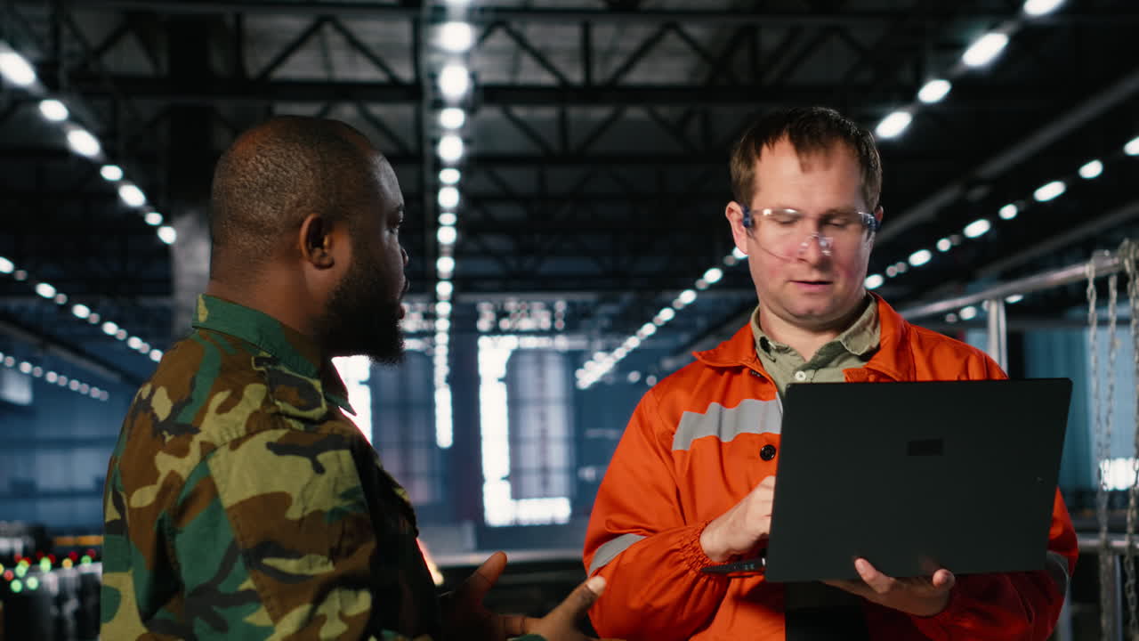 Staff and military officer in manufacturing plant converted for wartime industry