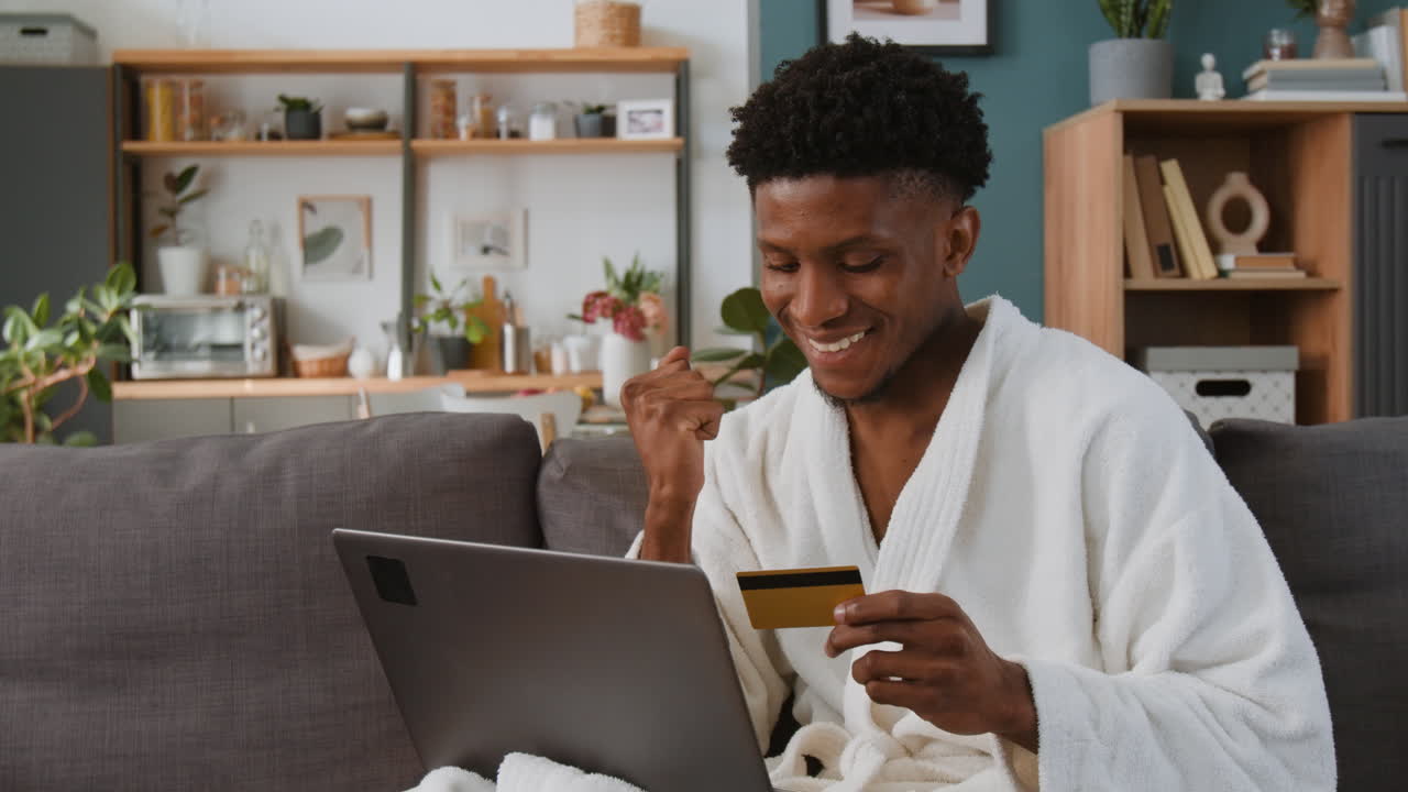 Man shopping online with credit card at home