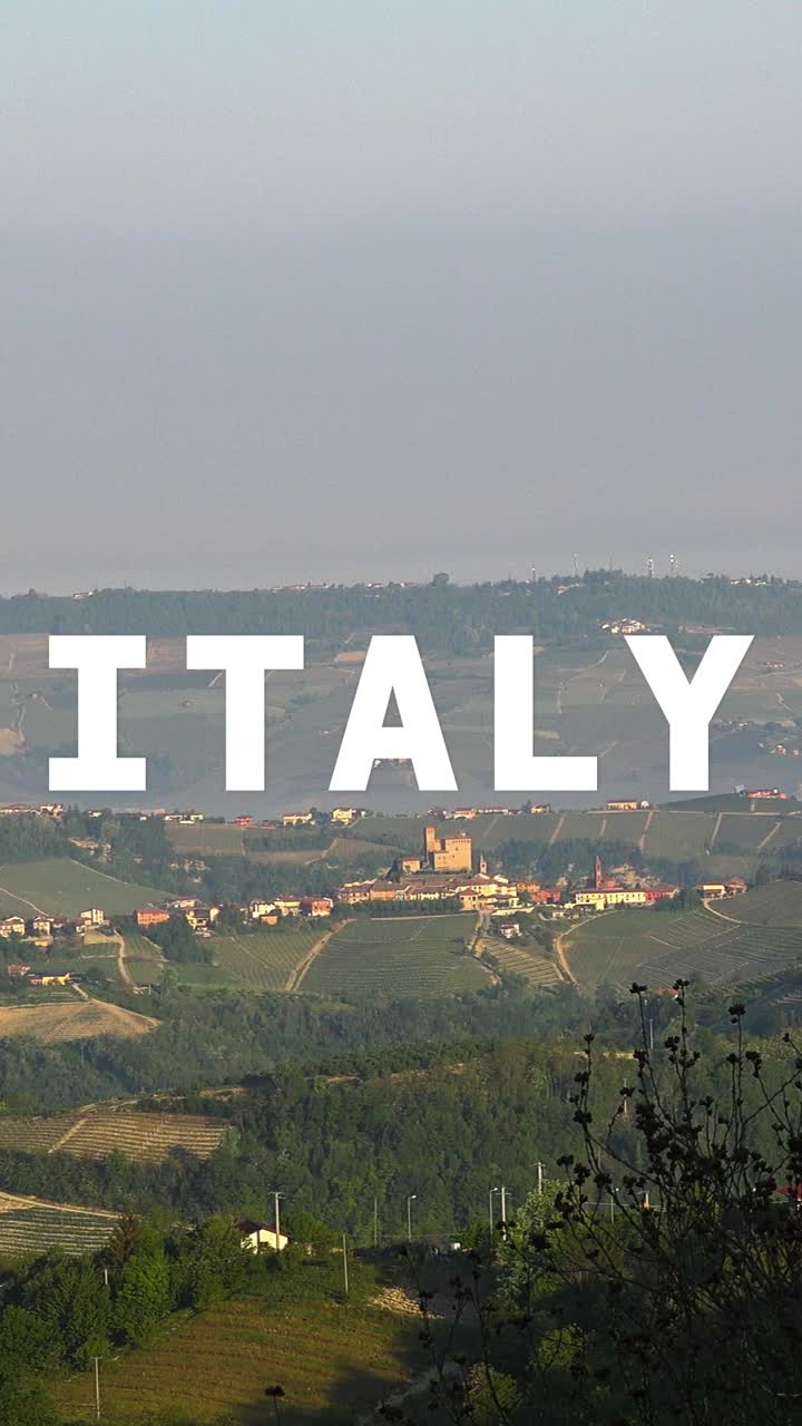video disparo vertical de aviones no tripulados de pueblos y montañas en italia con gráficos animados que deletrean italia