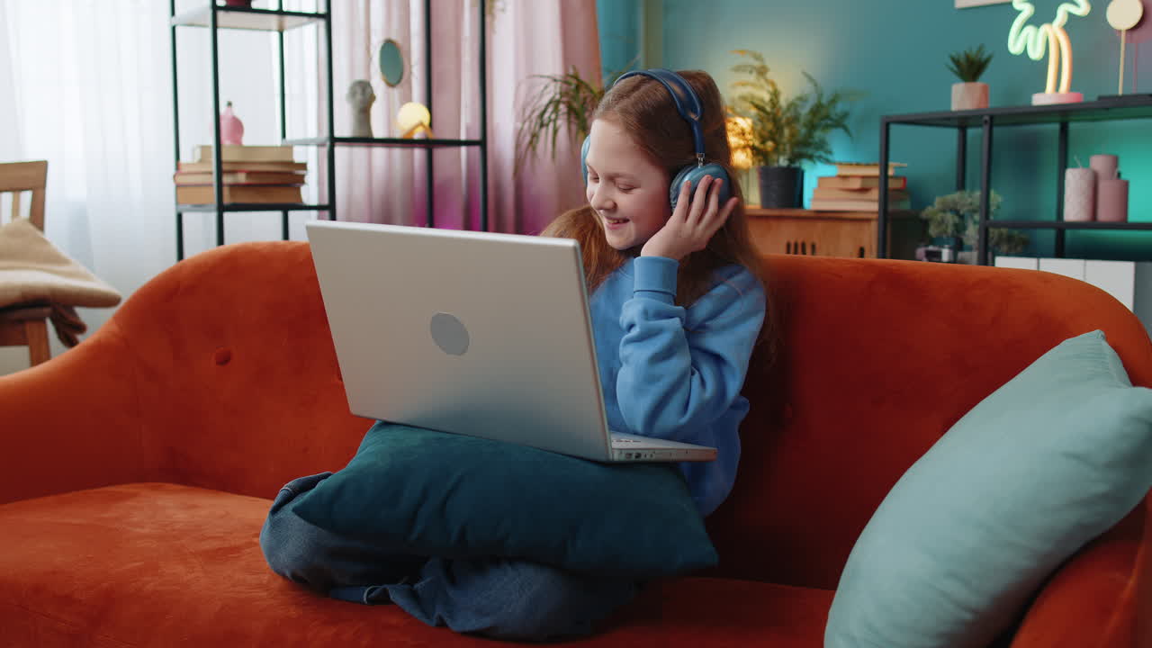 niña preadolescente con auriculares usando portátil escucha música o lección aprendizaje a distancia en línea