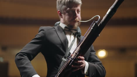 bassoonist in music hall musician is playing bassoon on scene of theatre or concert hall