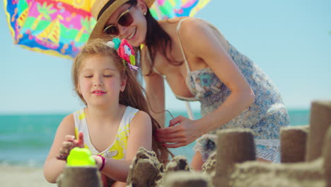 mother and daughter building sandcastles on the beach