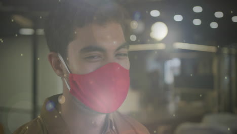 animation of glowing light spots over biracial man with face mask smiling
