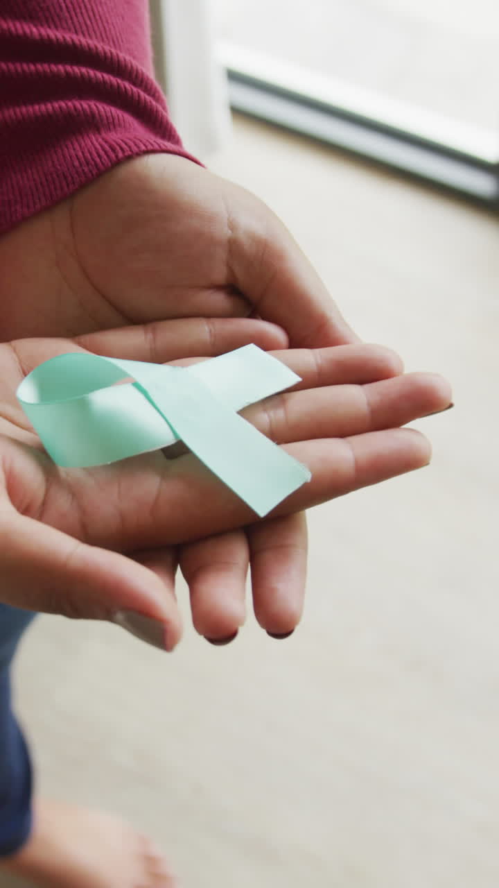 video de la sección media de una mujer afroamericana de tamaño plus que sostiene una cinta azul