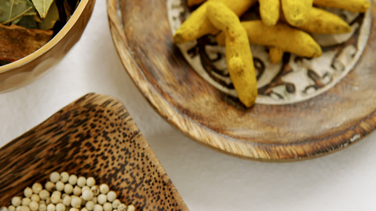 Turmeric raw seed, bay leaf and seed in bowl 4k