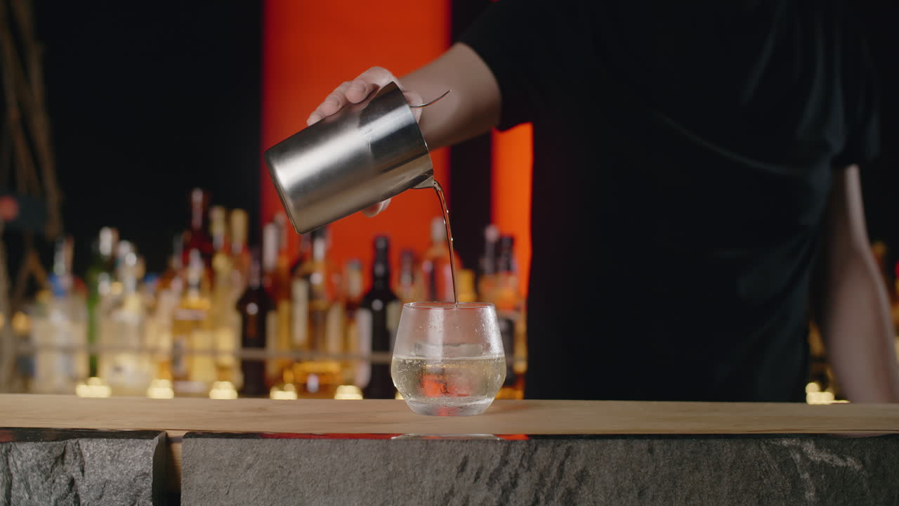 El camarero vertiendo un cóctel.