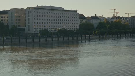 rising water levels along a riverside in front of a modern building during the budapest flood 2024