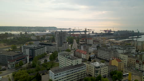 aerial view - gdynia cityscape on a cloudy sunset, marine cargo container port terminal on background