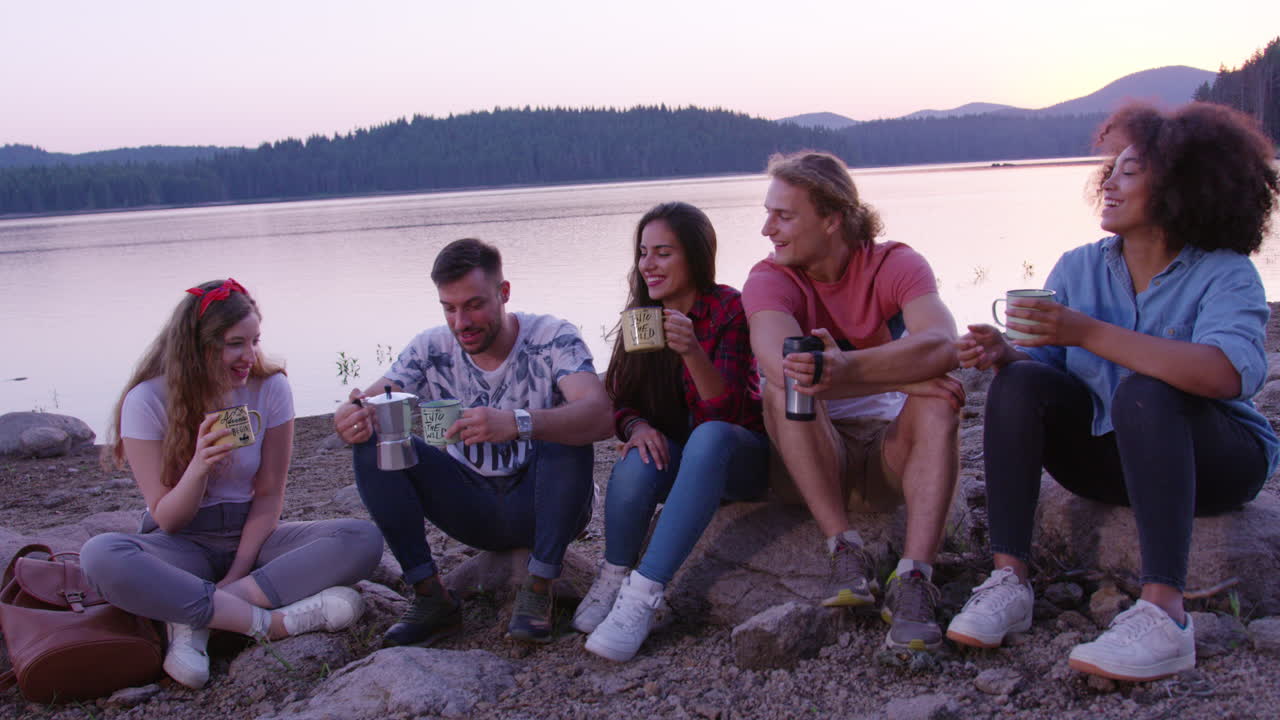 Friends Enjoying Coffee By The Lake At