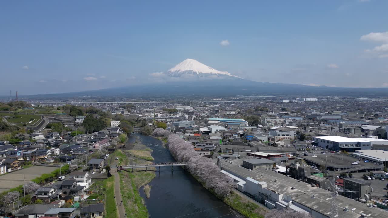 Slow motion high above drone flying over landscape with Mt. Fuji in distance