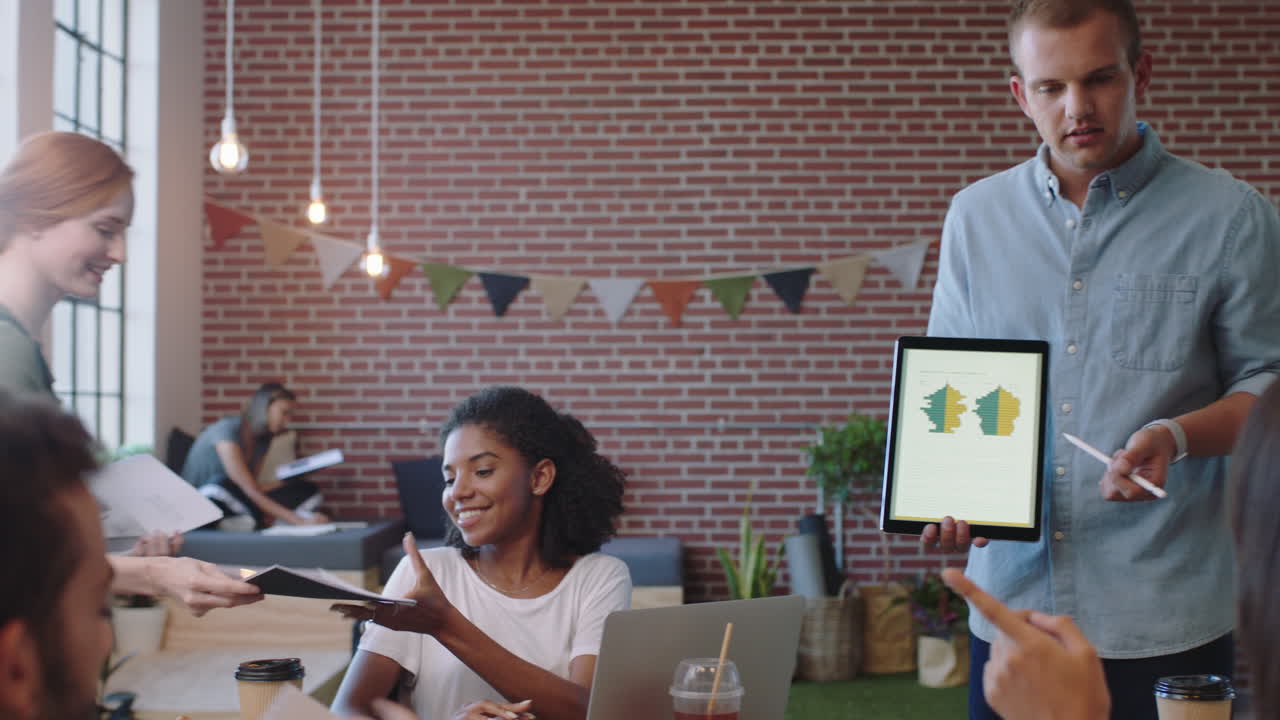 jóvenes empresarios que se reúnen empresario que presenta datos financieros utilizando una tableta que muestra a diversos colegas ideas de marketing en la presentación de la sala de juntas de la oficina