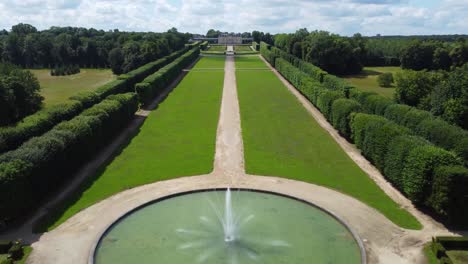 volando sobre una fuente y el jardín de un majestuoso castillo en francia