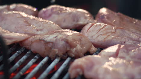 Closeup-raw-chicken-breasts-on-barbeque-grill.-Chicken-fillet-grilling-on-fire