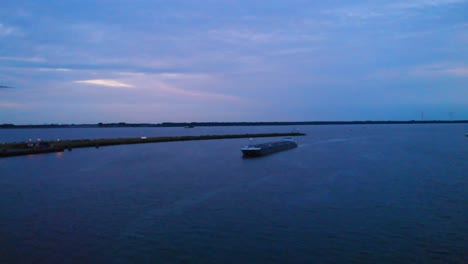 Aerial-View-Of-Minerva-Liquid-Tanker-Approaching-Inland-Waterway-Inlet-Along-Oude-Maas-During-Evening-Blue-Sky