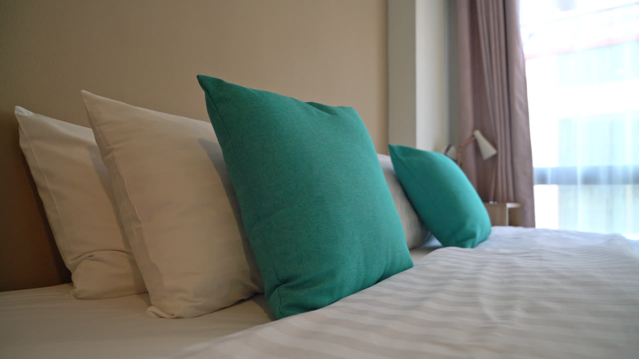 침실의 침대에 아름답고 편안한 베개 장식