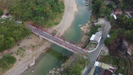 beautiful aerial view of a bridge over a river nestled between mountains