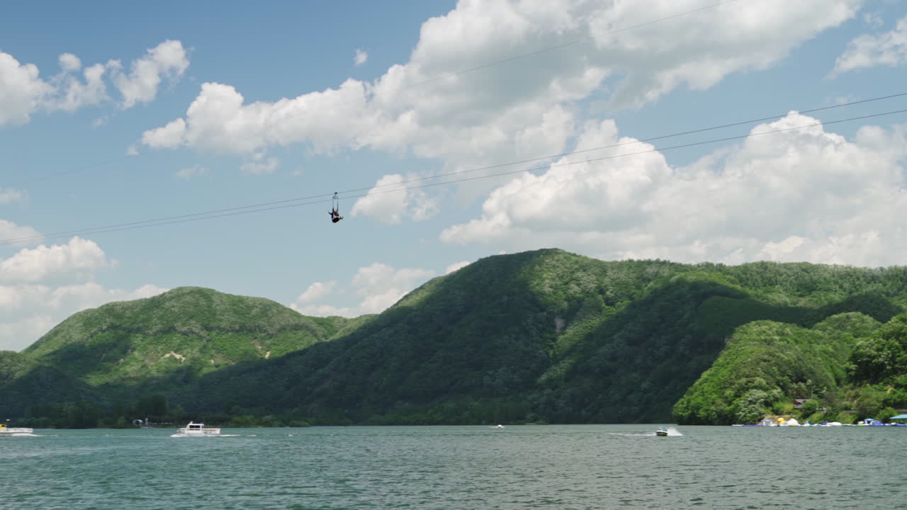 Nami Skyline Zipwire Ziprider zip line over the Han River as seen from a Nami Island ferry, wide track in slow motion.