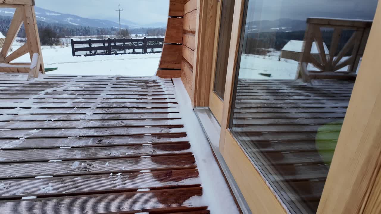 Snow Covered Wooden Deck and Cabin with Mountain View