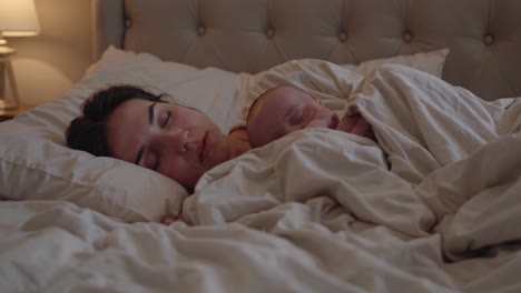 mother and newborn baby sleeping together