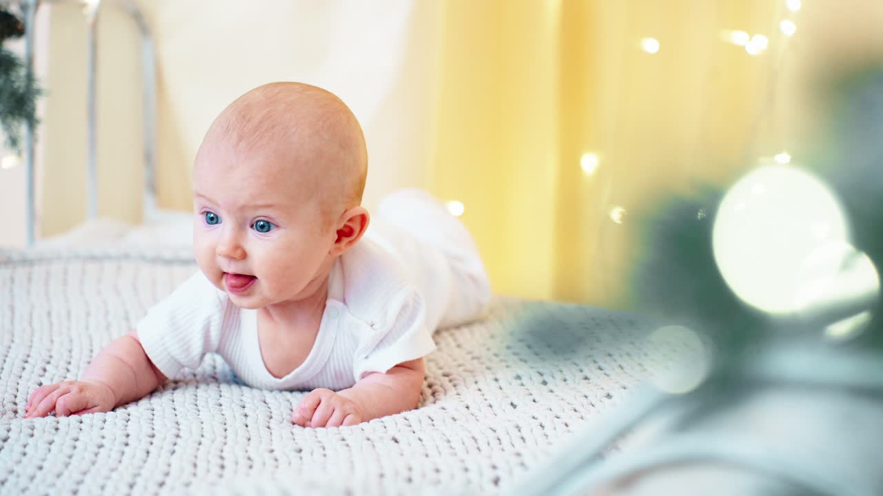 Søt baby ligger på magetid med bokeh-lys