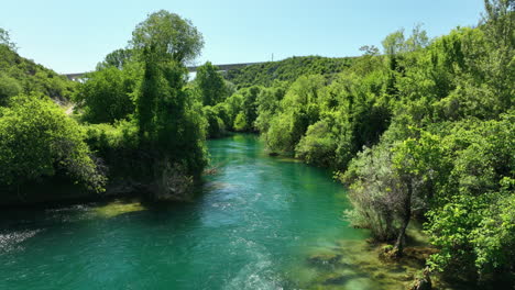 fast flowing river in bosnia surrounded by lush green landscapes