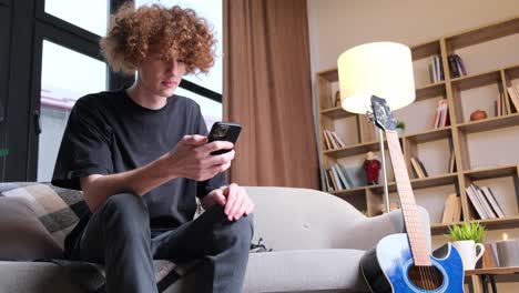 a young man with a strange hairstyle is talking on the phone a young man with a strange hairstyle is talking on the phone happy curly redhaired young man talking on the phone technologies and communications