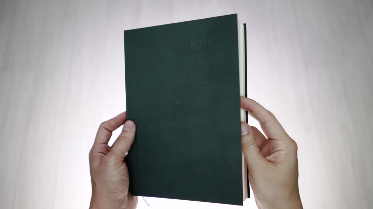 두 손이 빈 페이지로 책을 열고 있습니다.