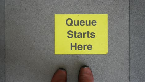 queue starts here sign on floor