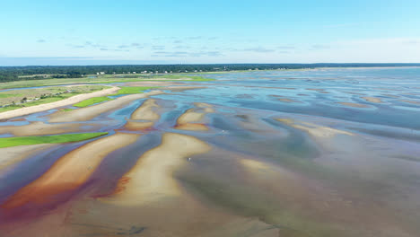 cape cod bay aerial drone footage of bay side beach at low tide with sand dunes and people walking in ocean