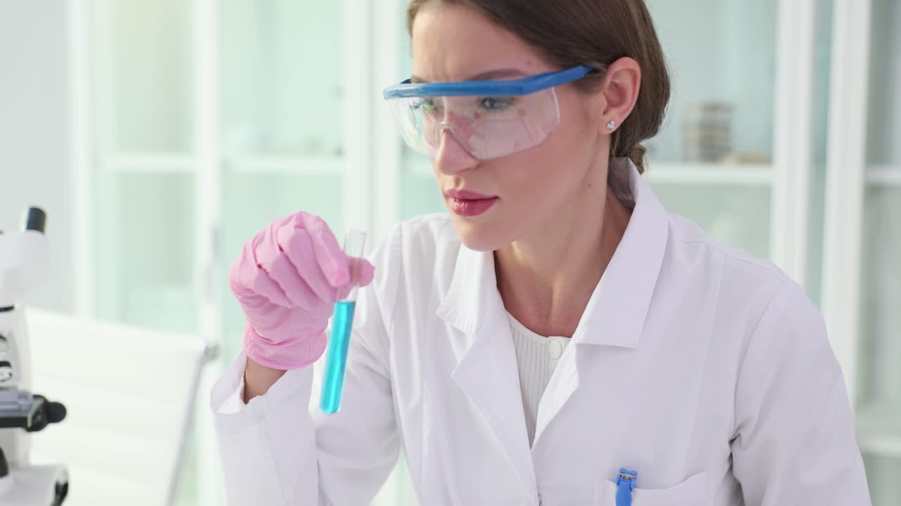 Female Scientist Examining Blue Liquid in Laboratory Test Tube