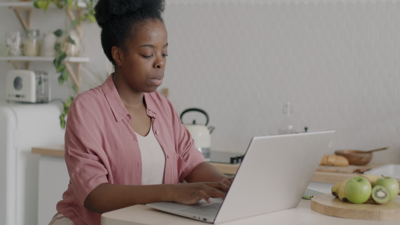 Woman Working on Laptop in Kitchen