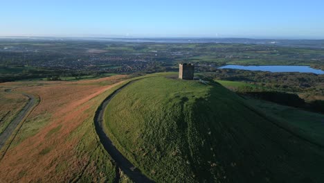 stone tower on hilltop in autumn morning light with slow orbit