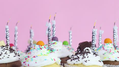 blowing cup candles on delicious sweet cup cakes for birthday party