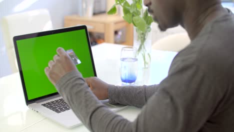 man entering card details on laptop 1