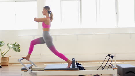 Mujer-Caucásica-Practicando-En-La-Máquina-Reformadora-De-Pilates