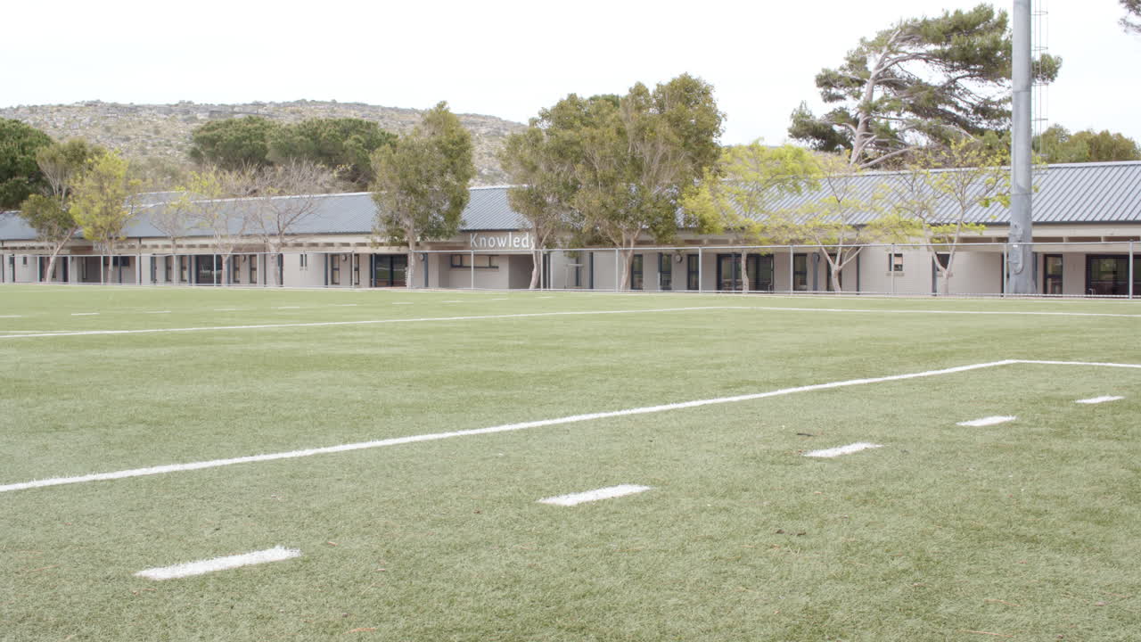 multiracial boys playing soccer on school field, enjoying outdoor activity