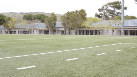 multiracial boys playing soccer on school field, enjoying outdoor activity