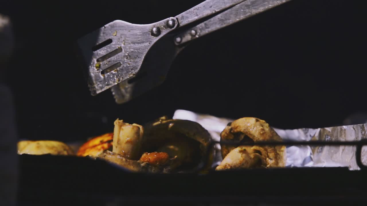 un poco más de cerca imágenes panorámicas de la tarde de las carnes de pollo cortadas y asadas, algunos champiñones en una bandeja sobre la pila de leña ligeramente quemada.