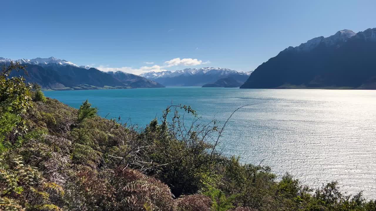 Serene Lake Hawea view in New Zealand with distant snowy peaks